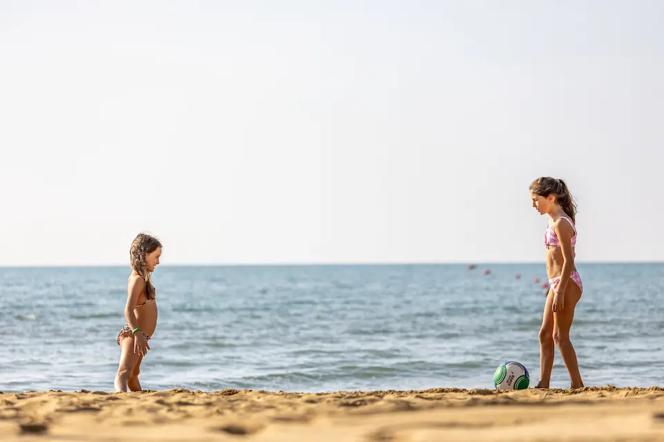 bambini che giocano con la palla sulla spiaggia di Bibione